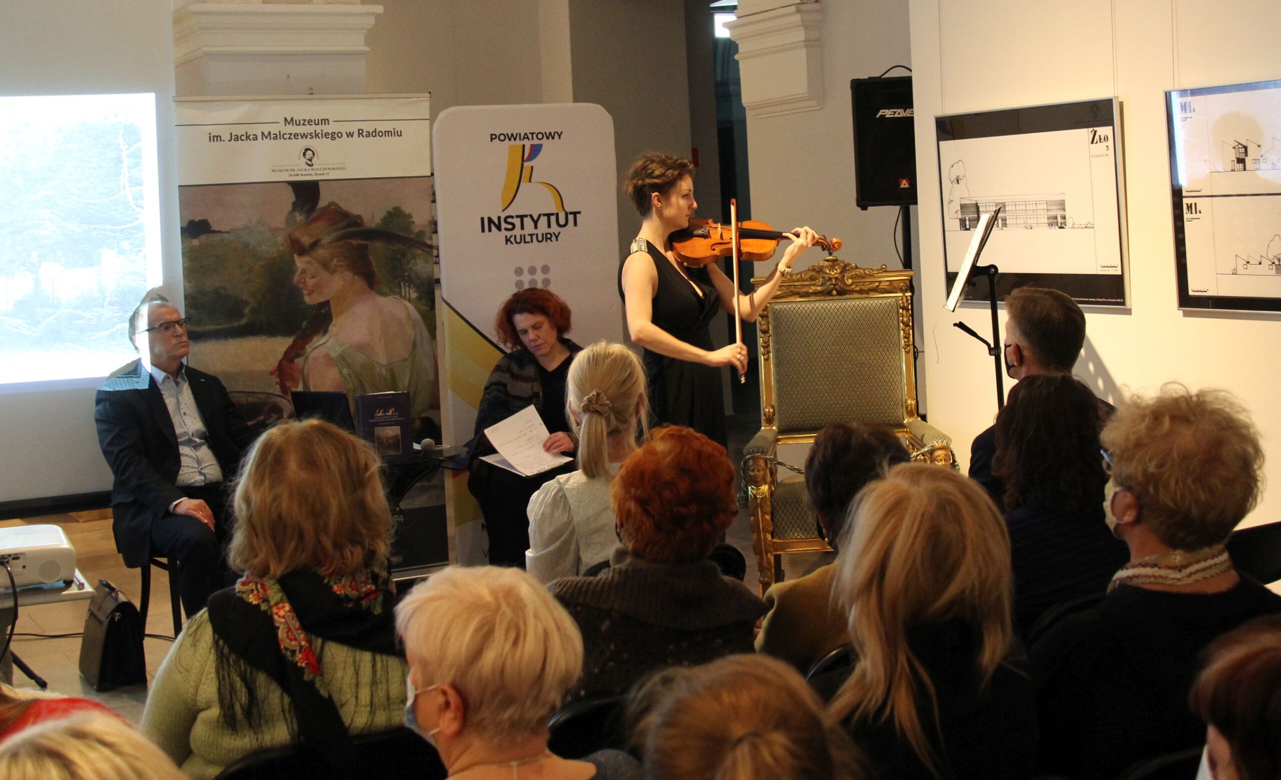 widownia słucha koncertu skrzypaczki, promocja książki M. Kowalika "Dwory i pałace"